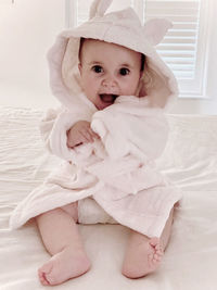 Portrait of cute baby girl on bed