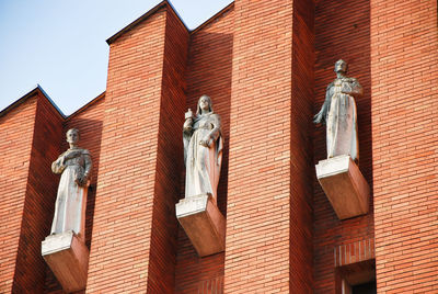 Statues on the facade of saint anthony's church in como, lombardy, italy.
