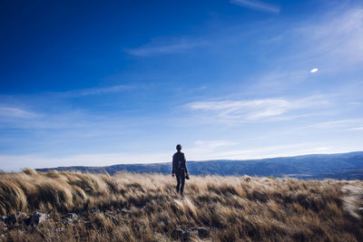 Rear view of woman looking at landscape against sky