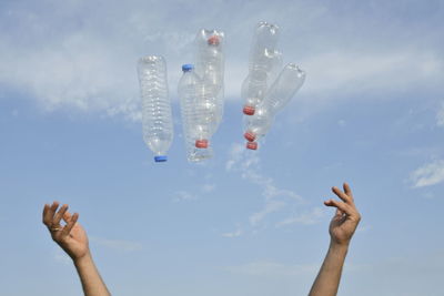 Low angle view of woman hand against sky