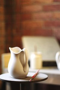 Close-up of jug and brush on table