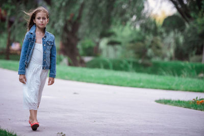 Portrait of girl walking on footpath