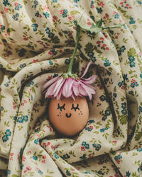 High angle view of painted egg on floral pattern fabric