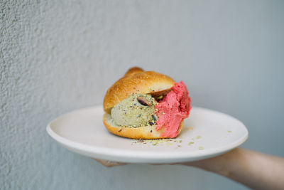 Close-up of hand holding dessert in plate