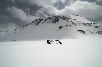 Helicopter on snowcapped mountain against sky