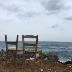 Chairs on beach against sky