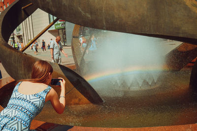 Woman photographing water fountain