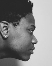 Close-up of young woman looking away against white background