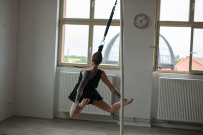 Full length of woman exercising on floor at home