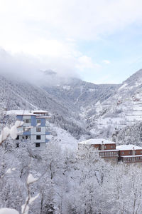 Snow covered buildings against sky