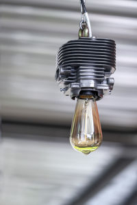 Close-up of light bulb hanging from ceiling