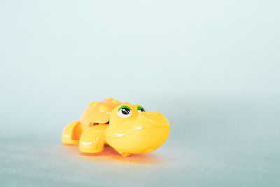 Close-up of yellow toy over white background