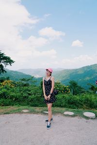 Woman standing on mountain against sky