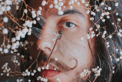 Close-up portrait of young woman with flowers