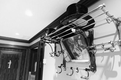 Low angle view of mirror and hat on metal rack mounted on wall at restaurant