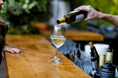 Midsection of woman holding wineglass