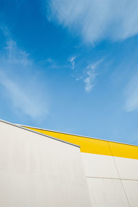 Low angle view of yellow building against blue sky