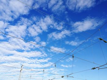Low angle view of power cables against sky