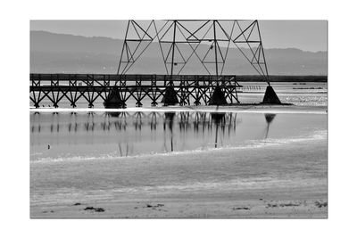 Pier on beach against sky