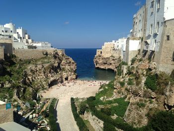 High angle view of buildings by sea against clear sky