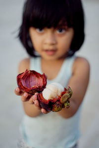 Portrait of girl holding mangosteen
