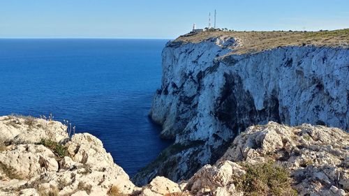 Rock formations by sea against sky
