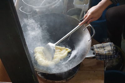 Midsection of person preparing food in kitchen