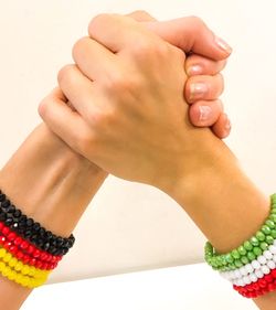 Close-up of woman holding hands over white background