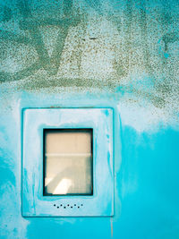 Close-up of window on blue wall