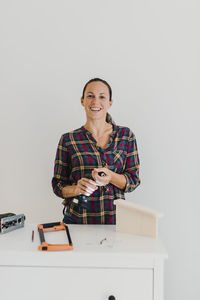 Portrait of a smiling young woman against white background