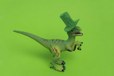 Close-up of lizard on toy over green background