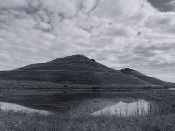 Scenic view of land and mountains against sky