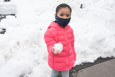 Girl standing on snow covered landscape