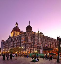 People in front of building against clear sky