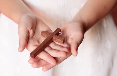 Midsection of woman holding religious cross