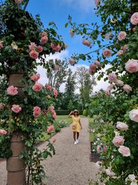 Woman standing by flowering plants