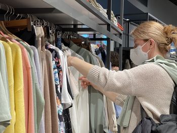 Full length of woman sitting in rack at store