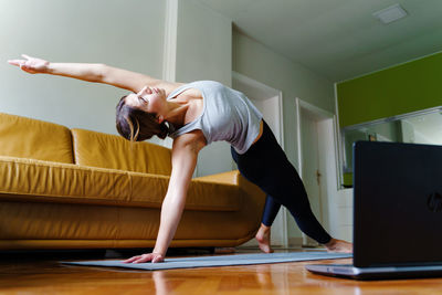 Woman with arms raised at home