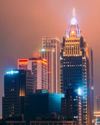 Illuminated cityscape against sky at night