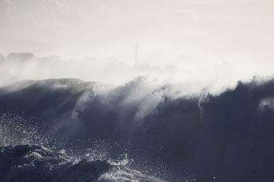 Water splashing in sea against sky