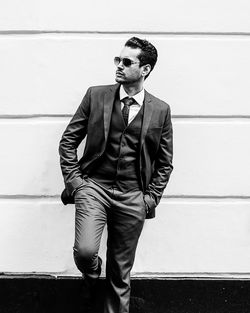 Young man standing against wall