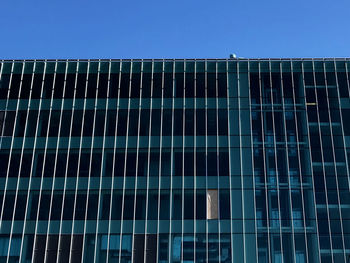 Low angle view of modern building against clear blue sky