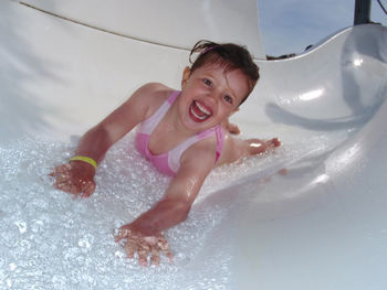 Portrait of happy girl enjoying water slide