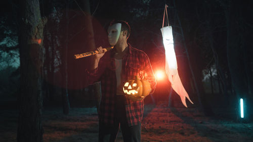 Rear view of man standing on street at night