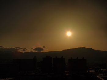 Silhouette cityscape against sky during sunset