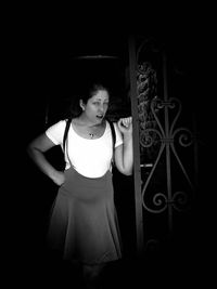 Portrait of a girl standing against black background