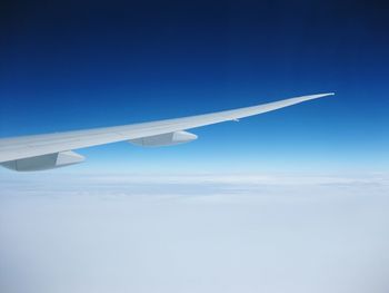 Airplane wing against blue sky