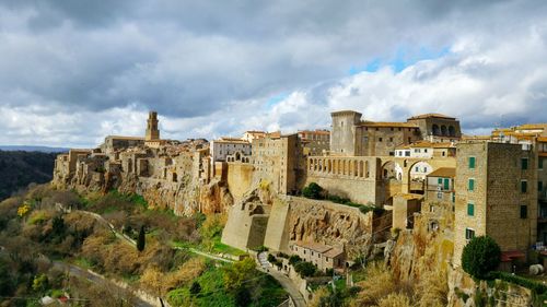 Historic buildings in pitigliano against cloudy sky