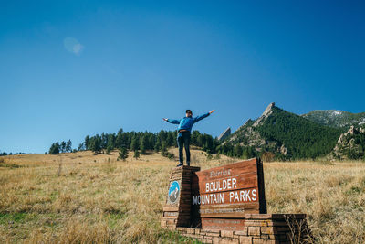 Man standing on field against clear blue sky