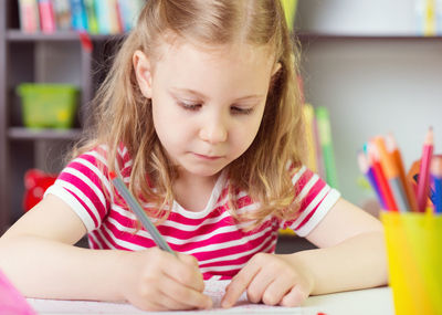 Girl drawing on paper at home